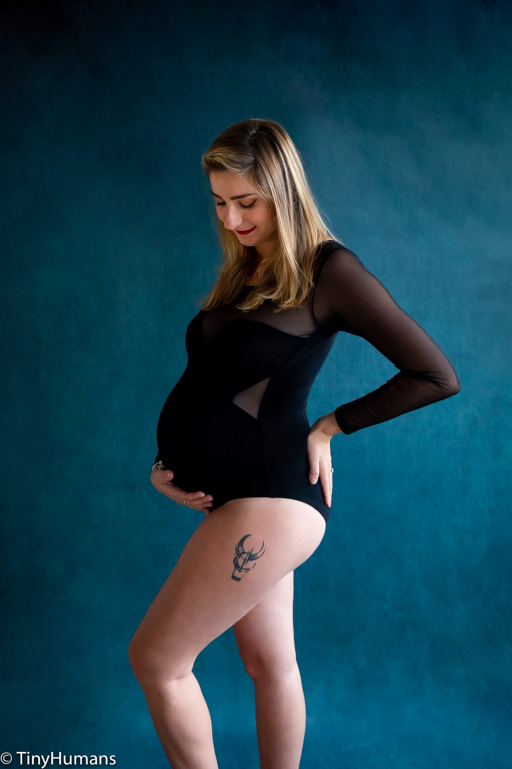 Pregnancy on blue backdrop at 32 weeks